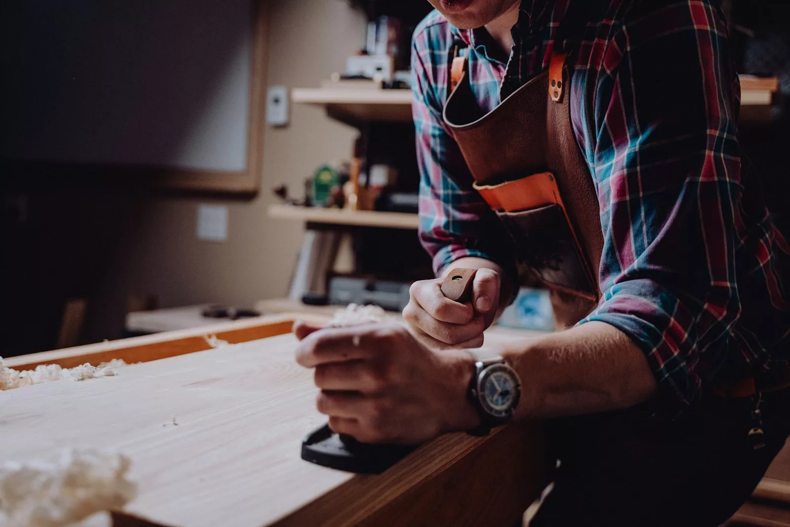Hands working a piece of wood in a workshop
