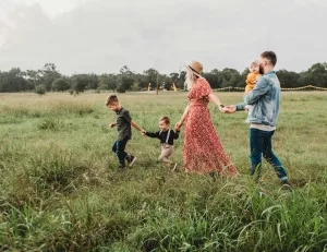 Woman holding man and toddler hands during daytime