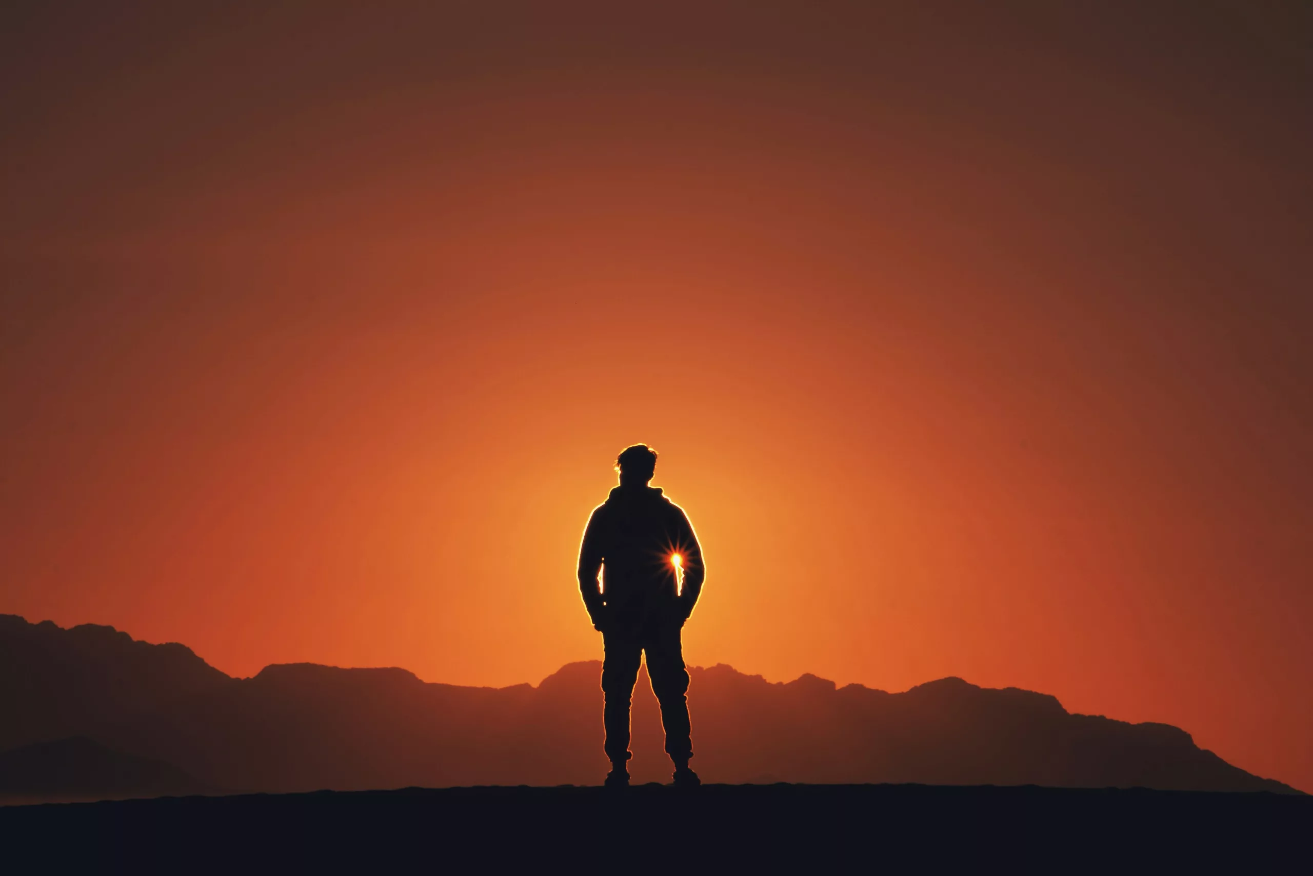 A person standing in silhouette at sunrise