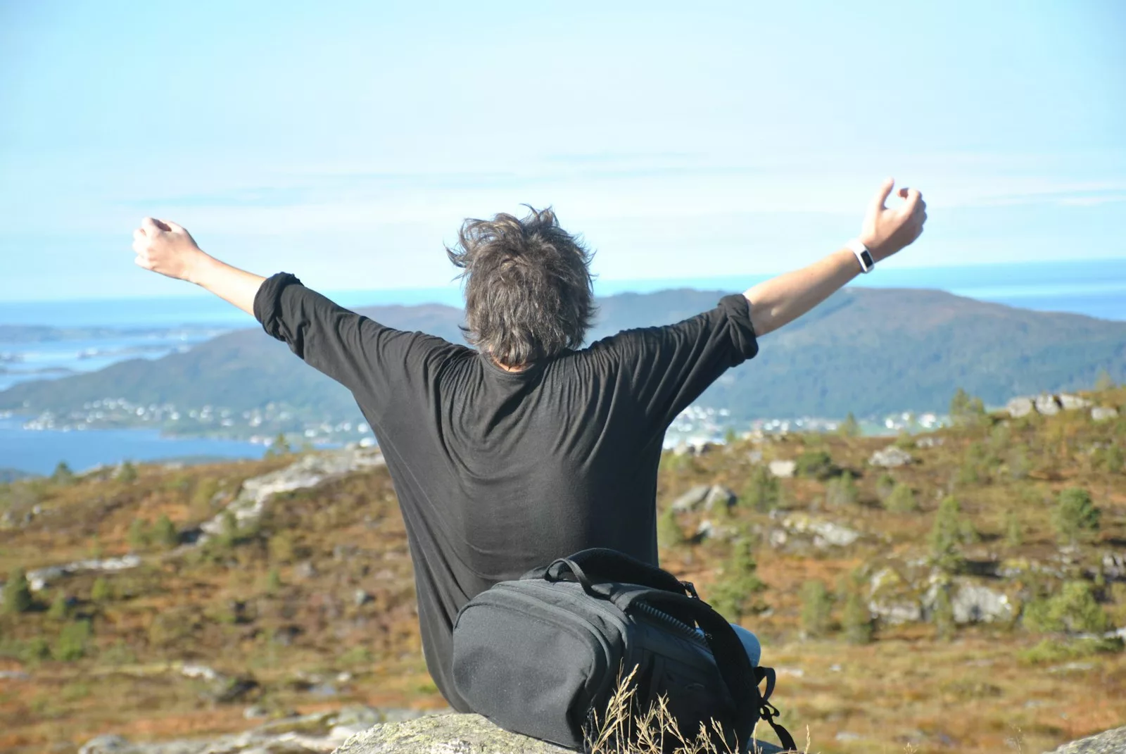 A person on a summit looking out over a vast landscape