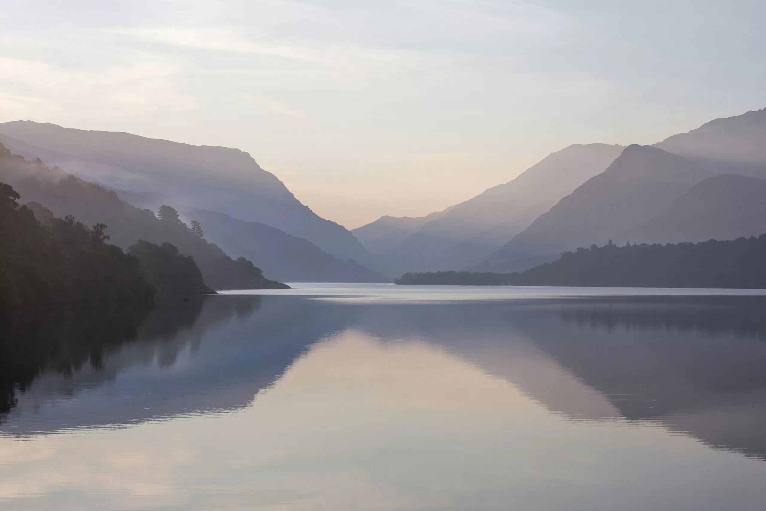 A calm, misty mountain lake at morning