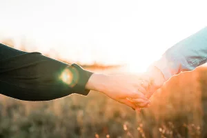 Two person holding each other's hands