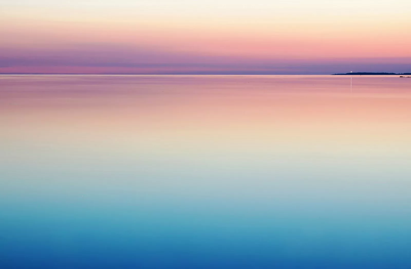 A calm, pastel sea and sky at dawn